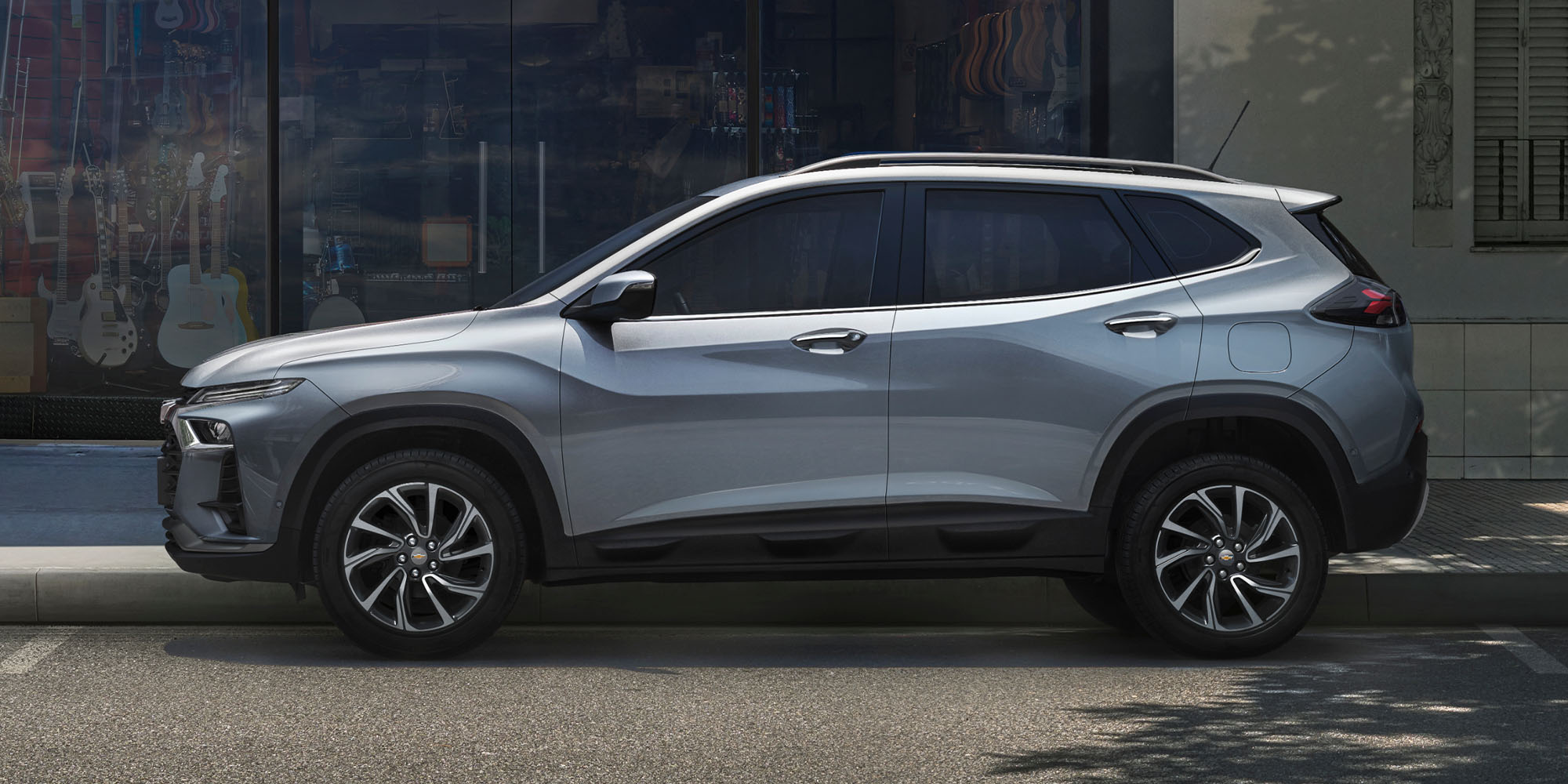 Chevrolet Tracker Turbo color plateado vista lateral estacionada en calle urbana